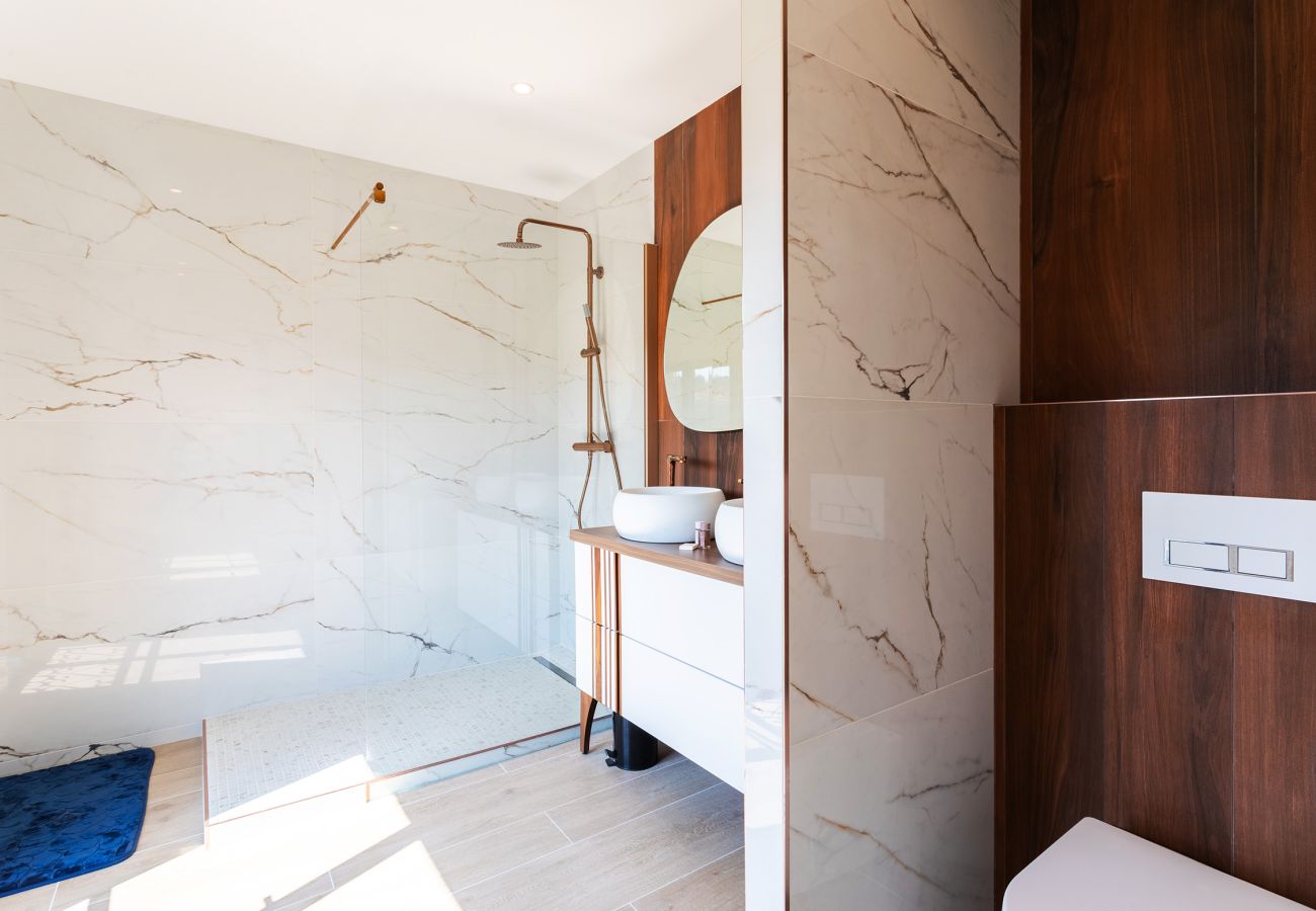Elegantes Badezimmer mit begehbarer Dusche, Design-Waschbecken und Marmoroberflächen. Ideal für einen erholsamen Aufenthalt.