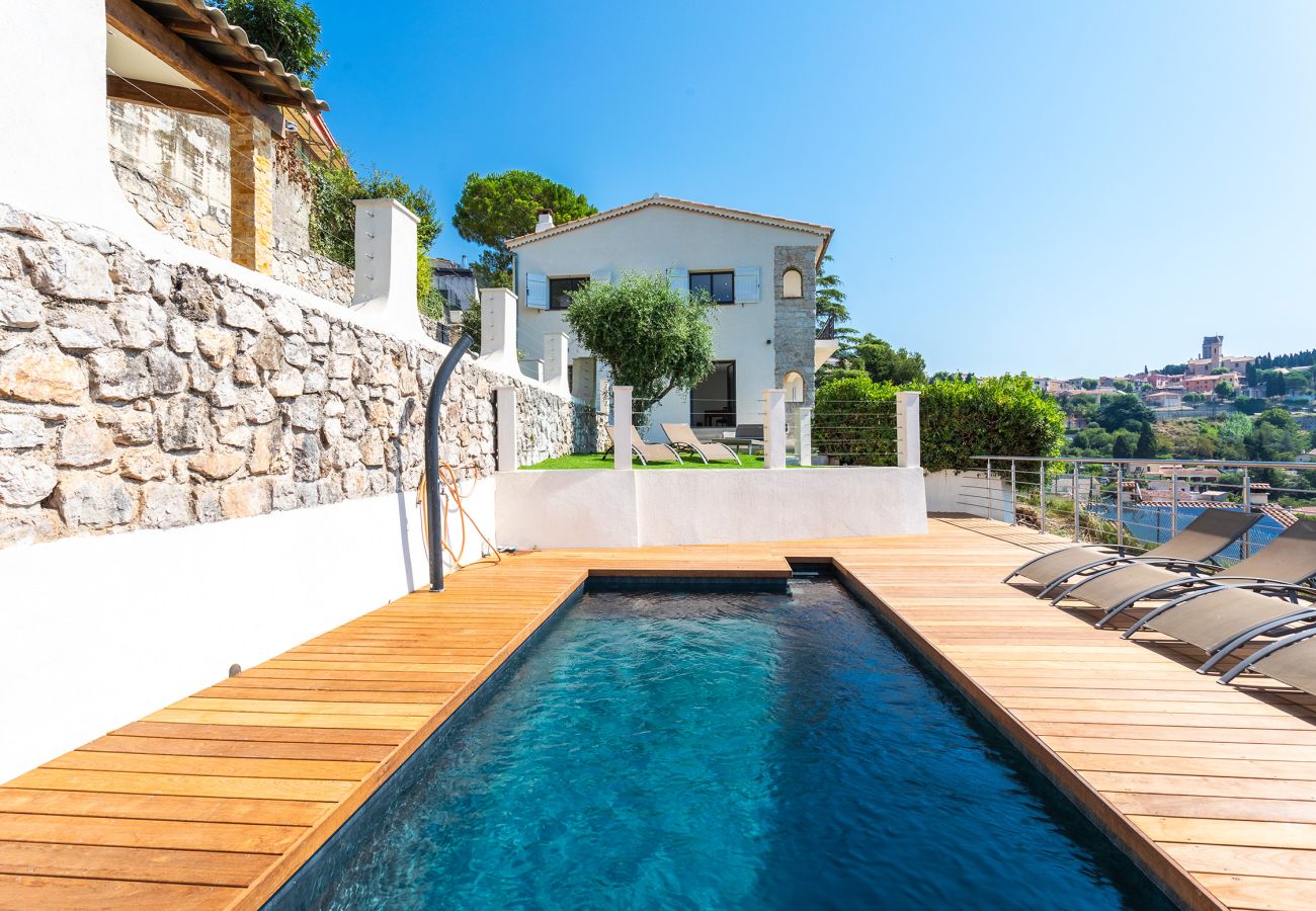 Villa in La Turbie mit Pool und Liegestühlen, die einen ruhigen Blick auf das Dorf und die umliegenden Hügel bietet.
