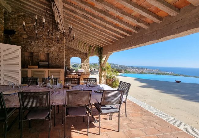 Photo de la terrasse couverte avec une belle table dressée et vue sur la mer à la Villa 83MAUR
