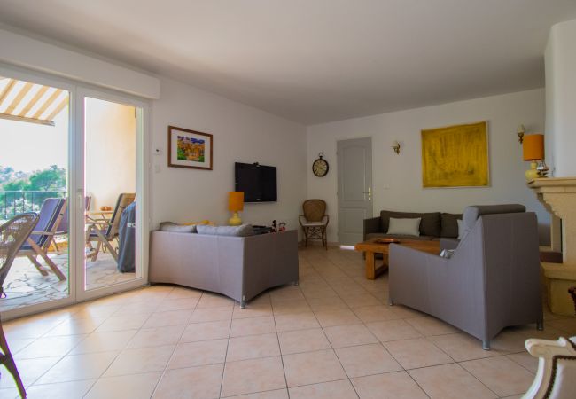 Photo du salon avec télévision et portes coulissantes donnant sur la terrasse à la Villa 83SYGU, Lorgues, Provence