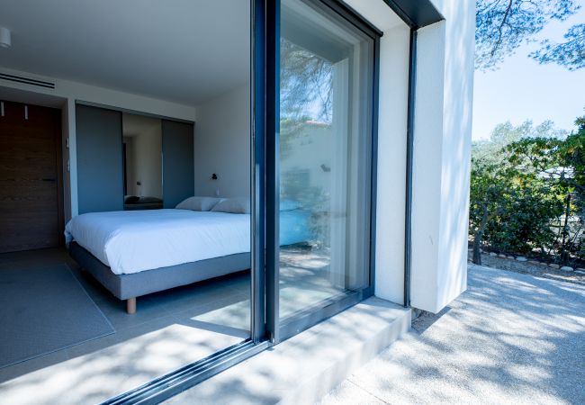 Villa Le 41 - Photo du luxueux lit boxspring avec magnifique linge de lit et climatisation, prise depuis la terrasse