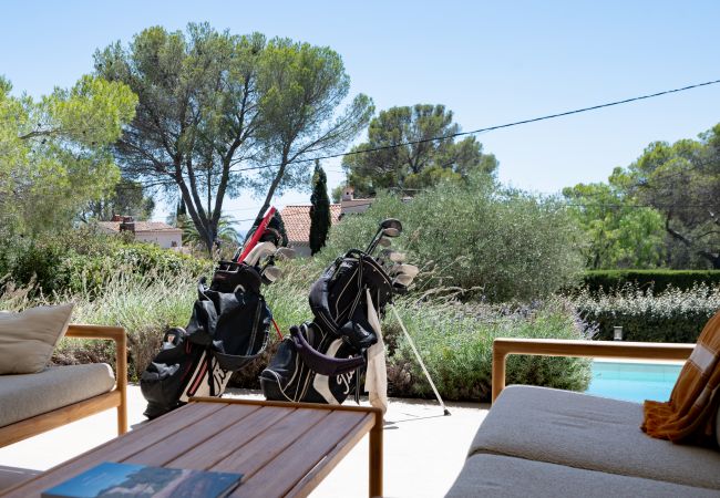 Villa Le 41 - salon de luxe avec sac de golf et vue sur la piscine