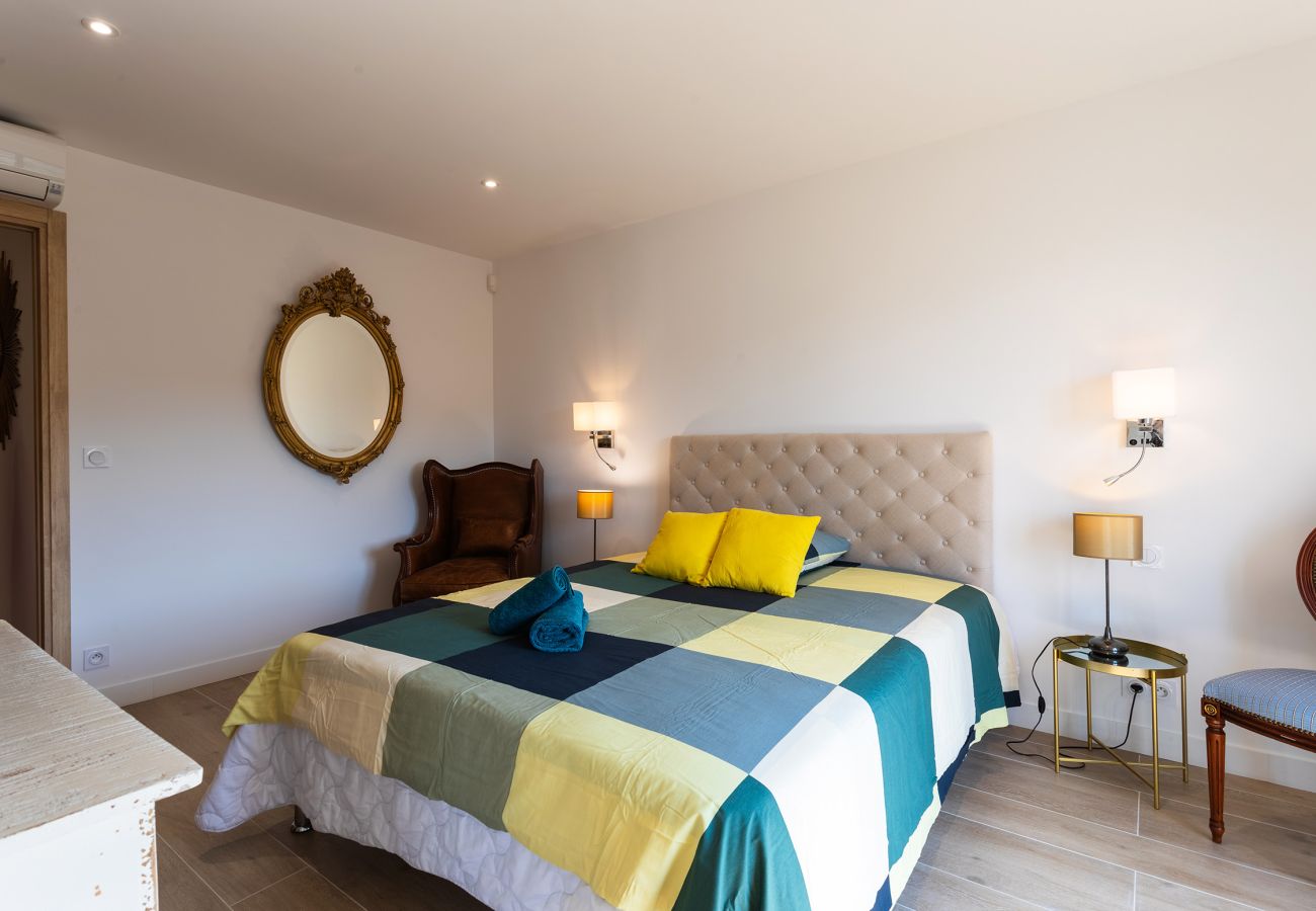 Bright bedroom with a double bed, tufted headboard, and vintage decor. Perfect for a comfortable, relaxing stay.